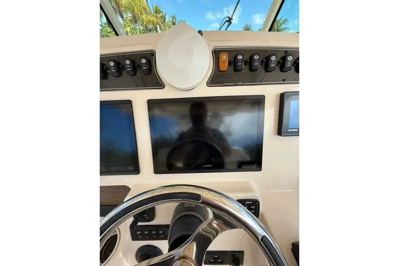 Slide: The Image of 2021 Grady-White Canyon 336 helm with Garmin displays and steering wheel. - 28