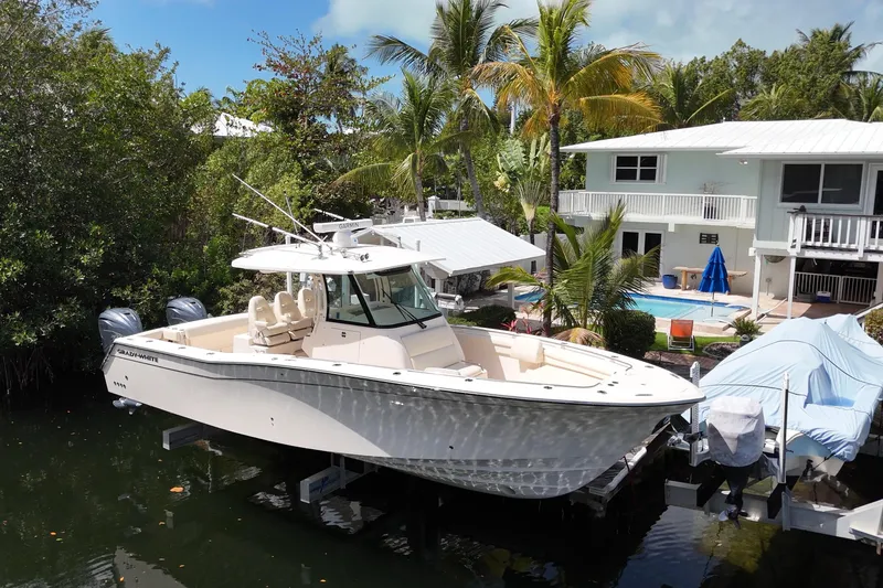 Slide: The Image of 2021 Grady-White Canyon 336 boat docked near tropical home with pool. - 3