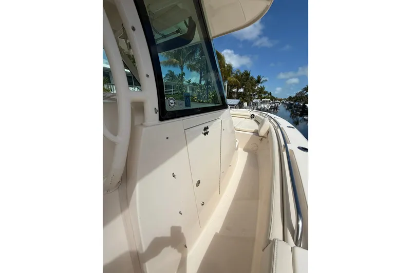 Slide: The Image of 2021 Grady-White Canyon 336 boat deck with clear skies and palm trees. - 35