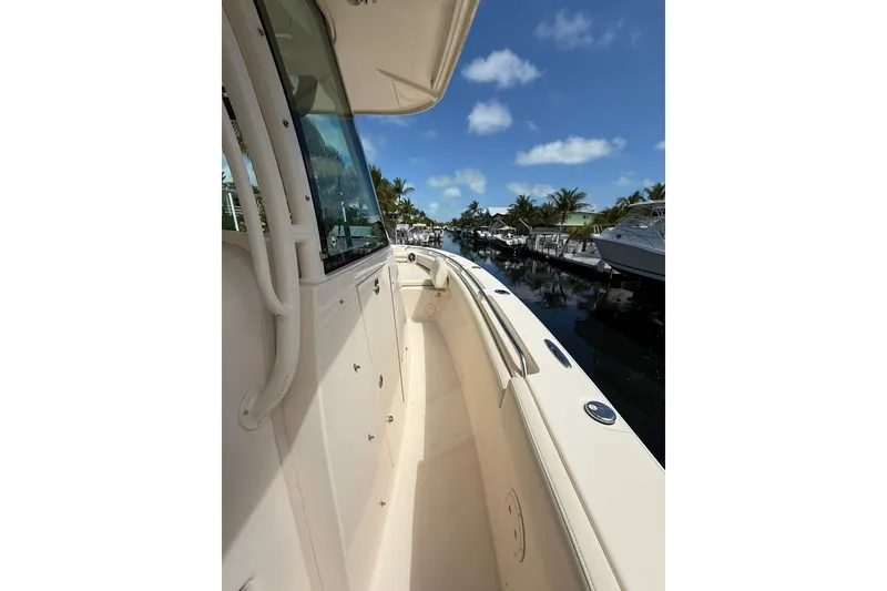 Slide: The Image of 2021 Grady-White Canyon 336 boat docked, showcasing sleek design and spacious deck. - 36
