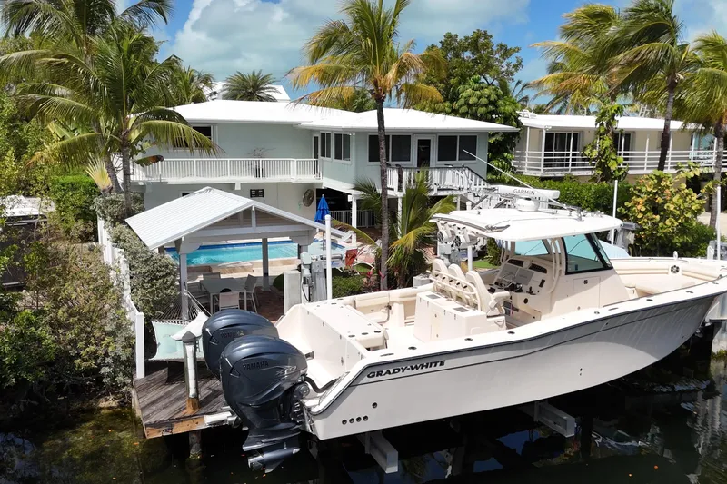 Slide: The Image of 2021 Grady-White Canyon 336 boat docked near tropical waterfront home. - 4