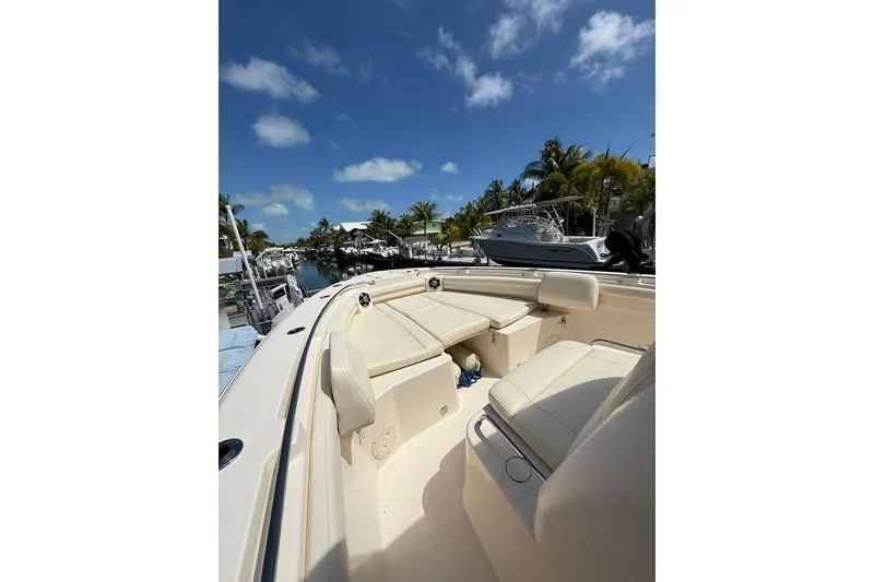 Slide: The Image of 2021 Grady-White Canyon 336 boat interior with seating, docked under a clear blue sky. - 41