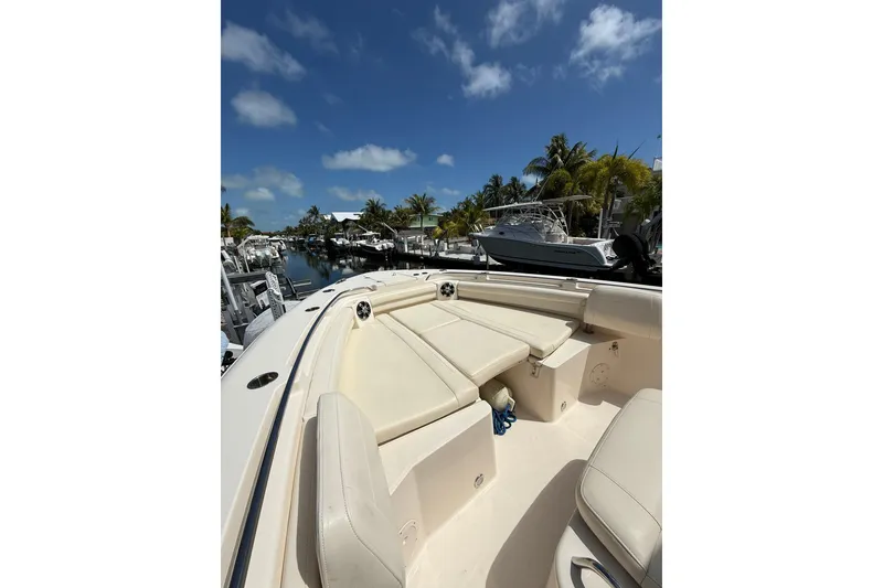 Slide: The Image of 2021 Grady-White Canyon 336 boat interior with seating, docked under clear blue sky. - 42