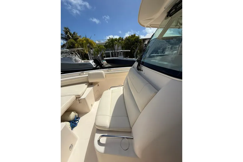 Slide: The Image of 2021 Grady-White Canyon 336 boat interior with seating, docked under clear sky. - 43