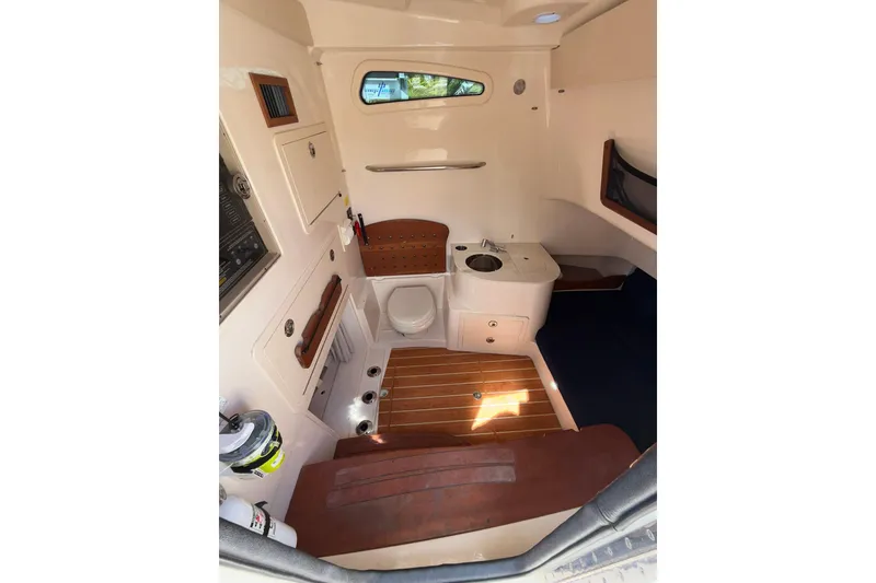 Slide: The Image of 2021 Grady-White Canyon 336 cabin interior with wood accents and compact amenities. - 48