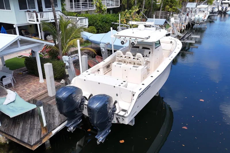 Slide: The Image of 2021 Grady-White Canyon 336 boat docked by waterfront homes. - 5