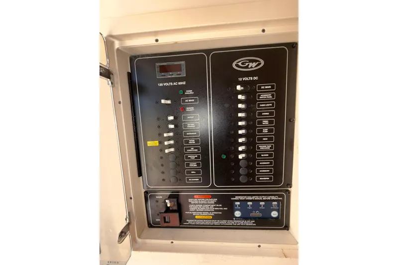 Slide: The Image of Electrical panel of a 2021 Grady-White Canyon 336 boat, showing AC and DC switches. - 53