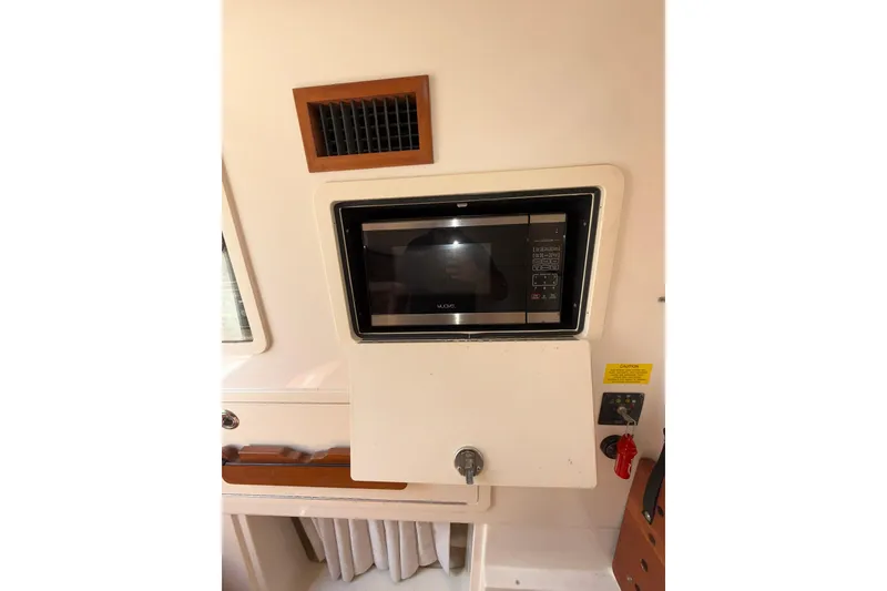 Slide: The Image of 2021 Grady-White Canyon 336 interior with built-in microwave and control panel. - 55