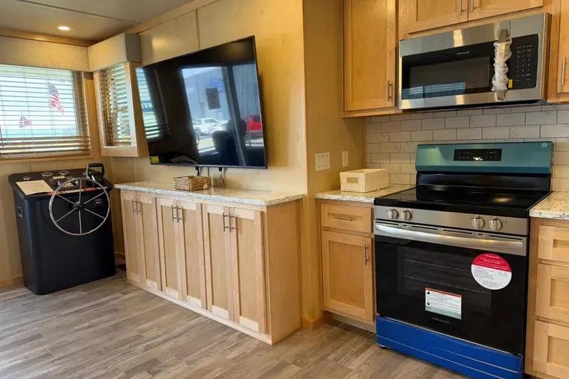 Slide: The Image of Modern kitchen interior in 2026 Sumerset Voyager houseboat with stove, TV, and helm station. - 5