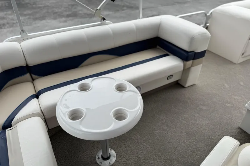Slide: The Image of 2007 SunCatcher LX 22 SE boat interior with cushioned seating and round table. - 11