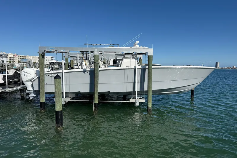 The Image of 2022 Invincible 40 Catamaran on lift, docked in marina under clear blue sky. - 1