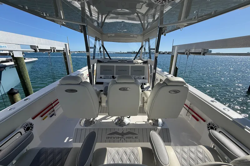 Slide: The Image of Interior view of 2022 Invincible 40 Catamaran with helm and seating, docked by the water. - 12