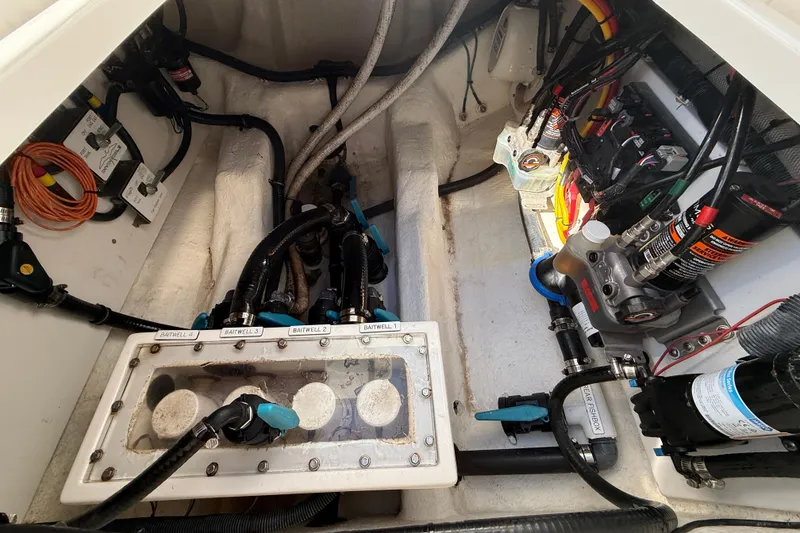 Slide: The Image of Engine compartment of a 2022 Invincible 40 Catamaran, showcasing baitwell system and wiring. - 22