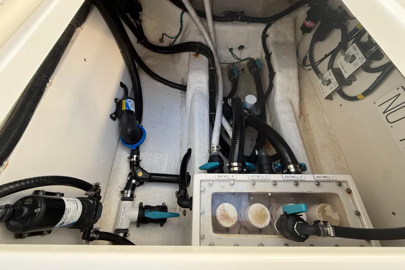 Slide: The Image of Engine compartment of 2022 Invincible 40 Catamaran with baitwell system and plumbing components. - 23