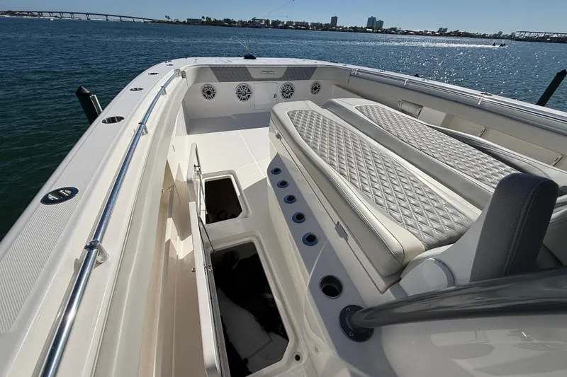 Slide: The Image of 2022 Invincible 40 Catamaran interior with cushioned seating and storage compartments on the water. - 5