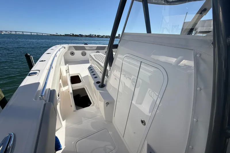 Slide: The Image of 2022 Invincible 40 Catamaran deck view with storage compartments, docked by the water. - 7