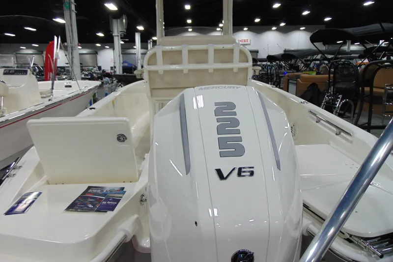 Slide: The Image of 2026 Boston Whaler 220 Dauntless with Mercury V6 engine displayed indoors. - 14