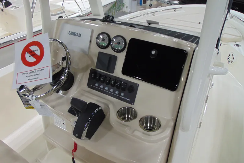Slide: The Image of 2026 Boston Whaler 220 Dauntless helm with steering wheel and control panel. - 16