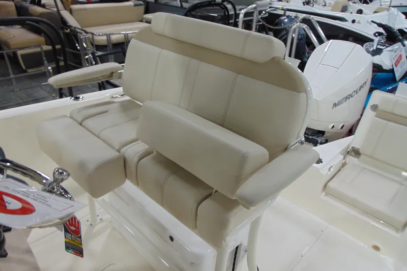 Slide: The Image of 2026 Boston Whaler 220 Dauntless boat interior with beige seating and Mercury engine. - 23