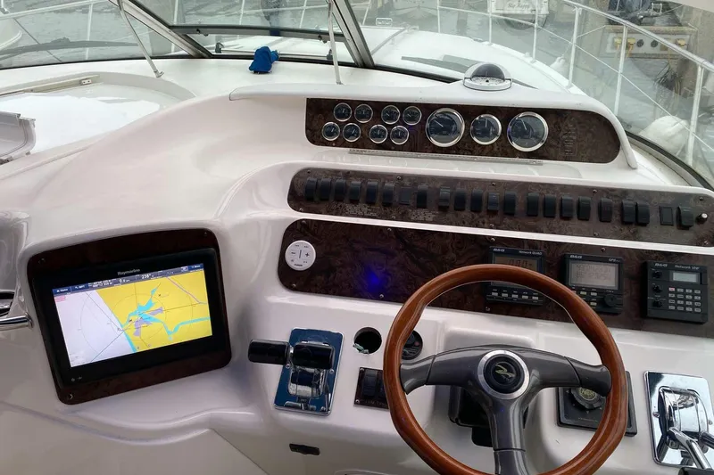 Slide: The Image of Cockpit of 1997 Sea Ray Sundancer 400 with navigation equipment and wooden steering wheel. - 14