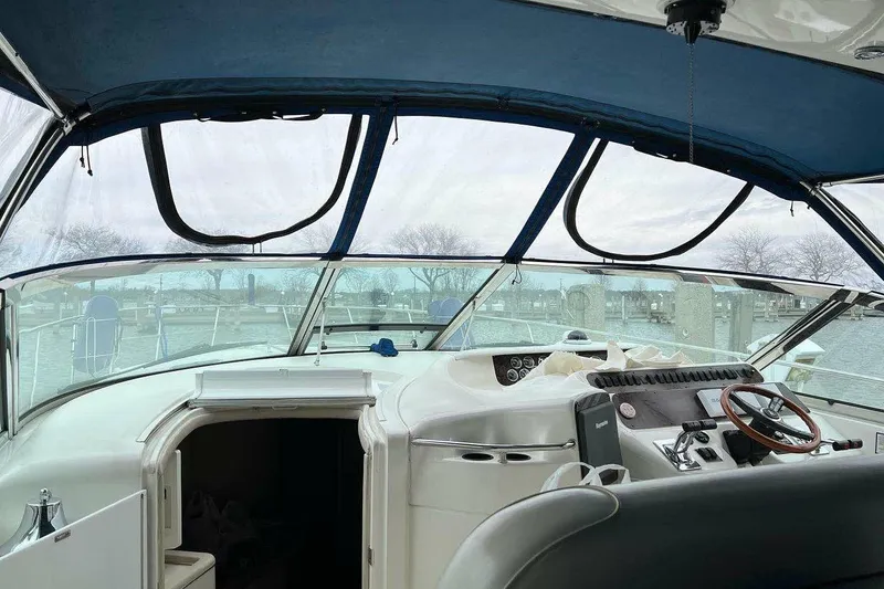 Slide: The Image of 1997 Sea Ray Sundancer 400 yacht cockpit with steering wheel and marina view. - 18