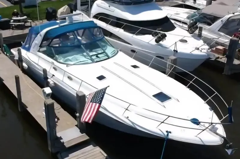 Slide: The Image of 1997 Sea Ray Sundancer 400 yacht docked with American flag, featuring sleek design and blue canopy. - 2