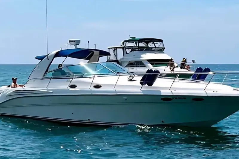 Slide: The Image of 1997 Sea Ray Sundancer 400 yacht cruising on clear blue waters. - 7