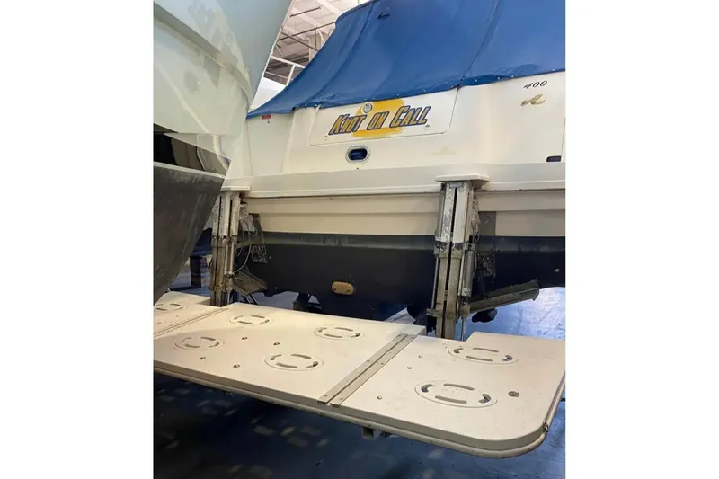 Slide: The Image of 1997 Sea Ray Sundancer 400 yacht with blue cover in a marina. - 9