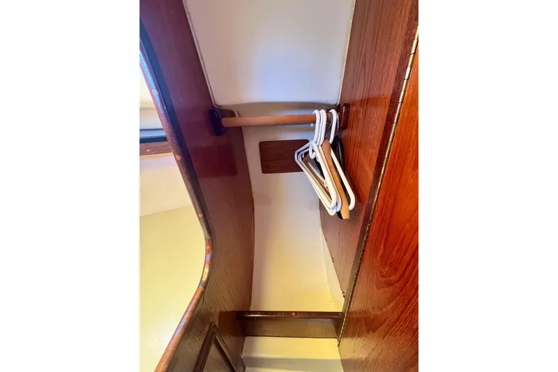 Slide: The Image of 1981 Cape Dory 25 sailboat interior with compact marine toilet and wooden cabinetry. - 12