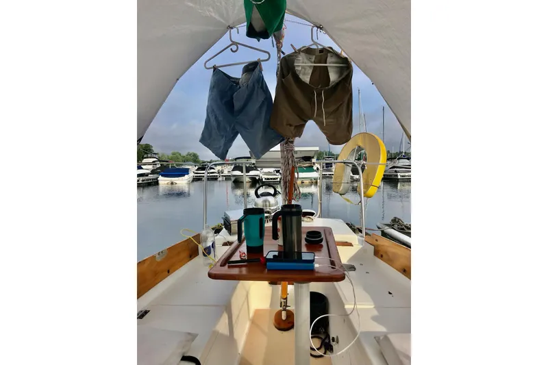 Slide: The Image of Interior of 1981 Cape Dory 25 sailboat with wooden finishes and blue cushions. - 14