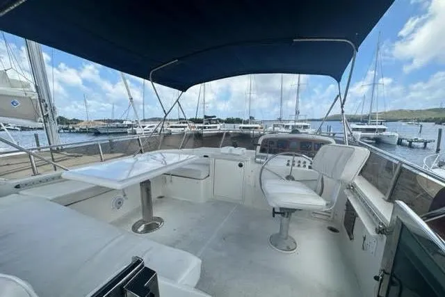 Slide: The Image of Spacious deck of 2001 Horizon 56 yacht with seating and helm, docked at marina. - 10