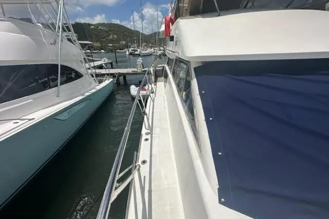 Slide: The Image of 2001 Horizon 56 yacht docked at marina, clear sky, surrounded by other boats. - 12