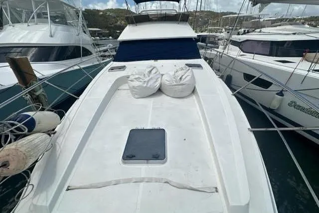 Slide: The Image of 2001 Horizon 56 yacht docked, featuring spacious deck with cushions and hatch. - 3