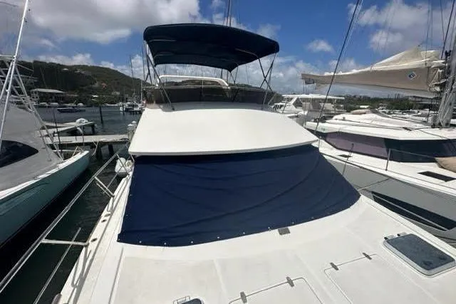 Slide: The Image of Luxury Horizon 56 yacht from 2001 docked at a marina under a clear blue sky. - 4