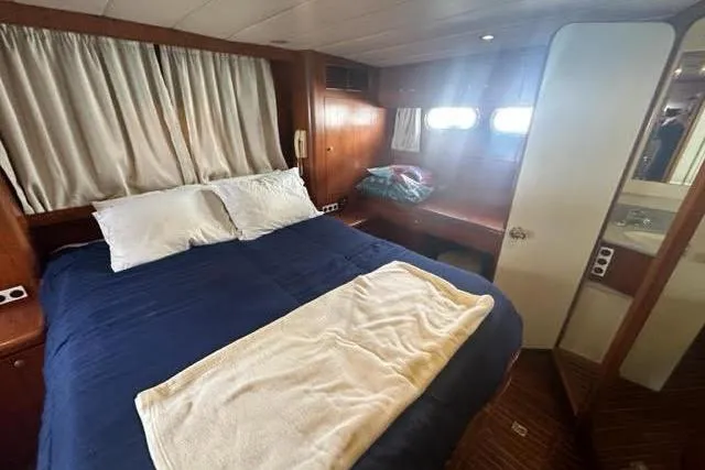 Slide: The Image of Cozy cabin interior of 2001 Horizon 56 yacht with bed and porthole windows. - 40