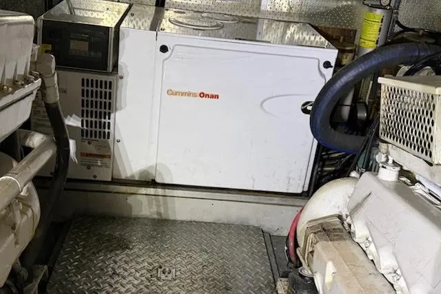 Slide: The Image of Cummins Onan generator in a 2001 Horizon 56 engine room, surrounded by machinery. - 45