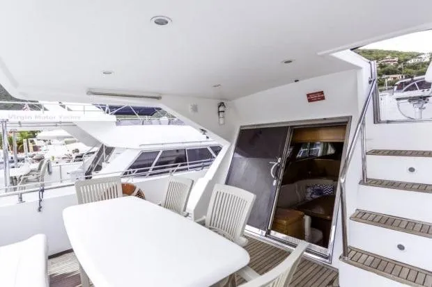 Slide: The Image of Outdoor dining area on a 2001 Horizon 56 yacht with stairs and sliding door. - 5