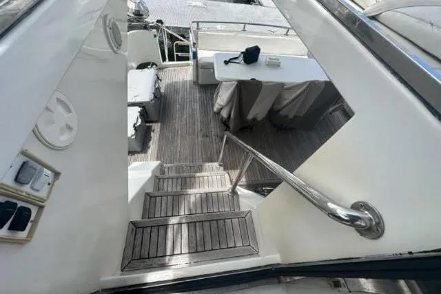 Slide: The Image of Staircase leading to deck area on 2001 Horizon 56 yacht with table and chairs. - 7