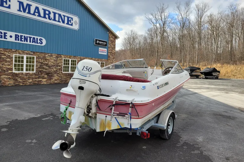 Slide: The Image of 1997 Four Winns 180 Horizon boat on trailer outside marine store. - 6