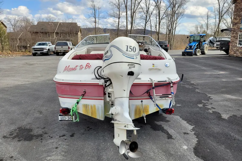 Slide: The Image of 1997 Four Winns 180 Horizon boat with outboard motor, parked outdoors. - 7