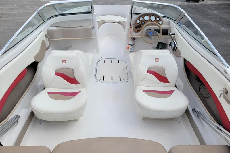 Slide: The Image of 1997 Four Winns 180 Horizon boat interior with white and red seating, dashboard, and steering wheel. - 8
