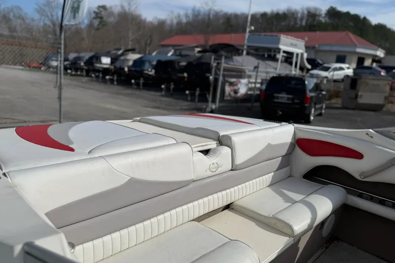 Slide: The Image of 2008 Stingray 205 LS/LX/LR boat interior with white and red seating, parked outdoors. - 6