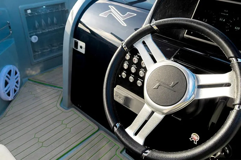 Slide: The Image of Steering wheel and dashboard of 2026 NX Boats NX260, featuring modern controls. - 12