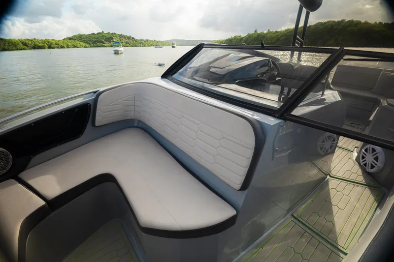Slide: The Image of 2026 NX Boats NX260 interior with sleek seating and modern design on a scenic waterway. - 6