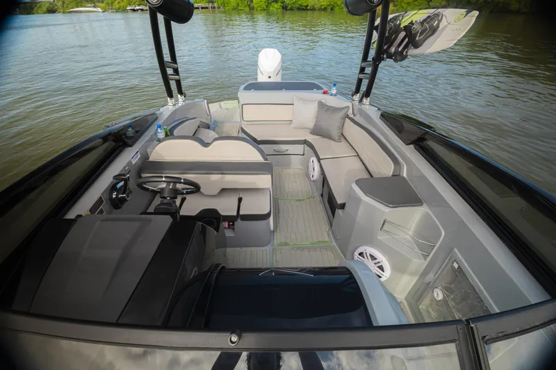 Slide: The Image of 2026 NX Boats NX260 interior with modern seating and steering, on a calm lake. - 7