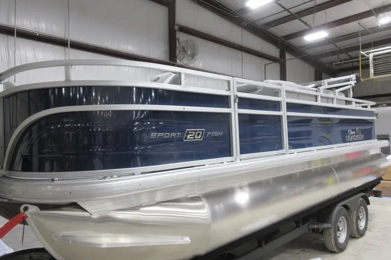 The Image of 2026 Sun Tracker SportFish 20 DLX pontoon boat in a warehouse setting. - 0