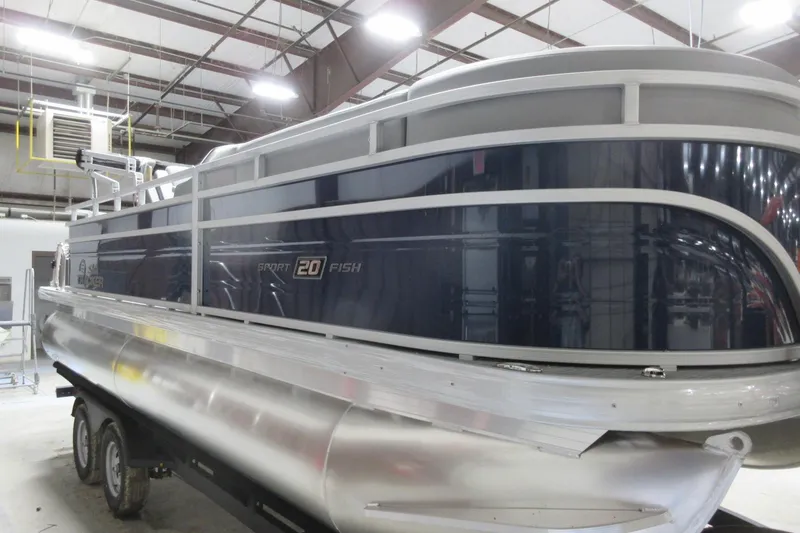 Slide: The Image of 2026 Sun Tracker SportFish 20 DLX pontoon boat in a warehouse setting. - 2