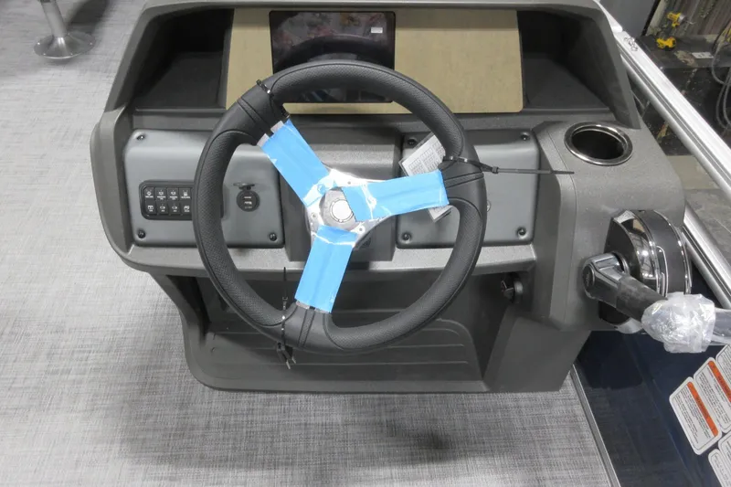 Slide: The Image of Steering console of 2026 Sun Tracker SportFish 20 DLX boat with controls and cup holder. - 5
