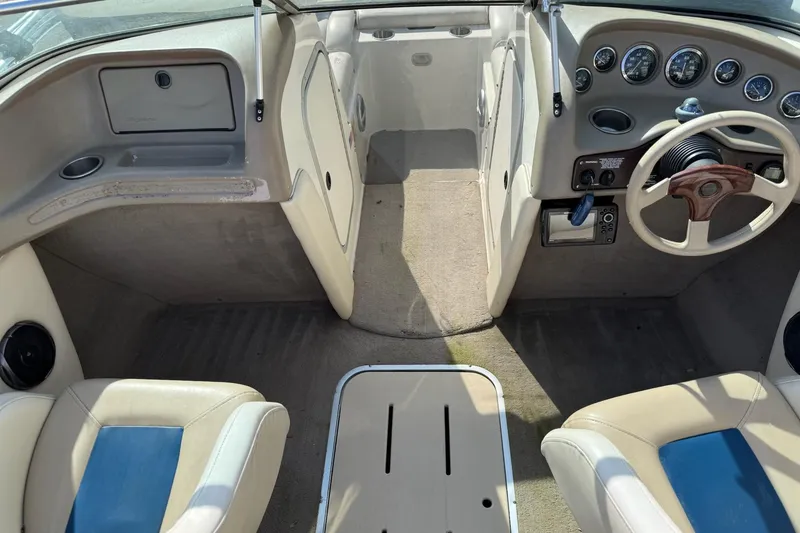 Slide: The Image of 1998 Bryant 214 Limited boat interior with beige and blue seating, dashboard, and steering wheel. - 10