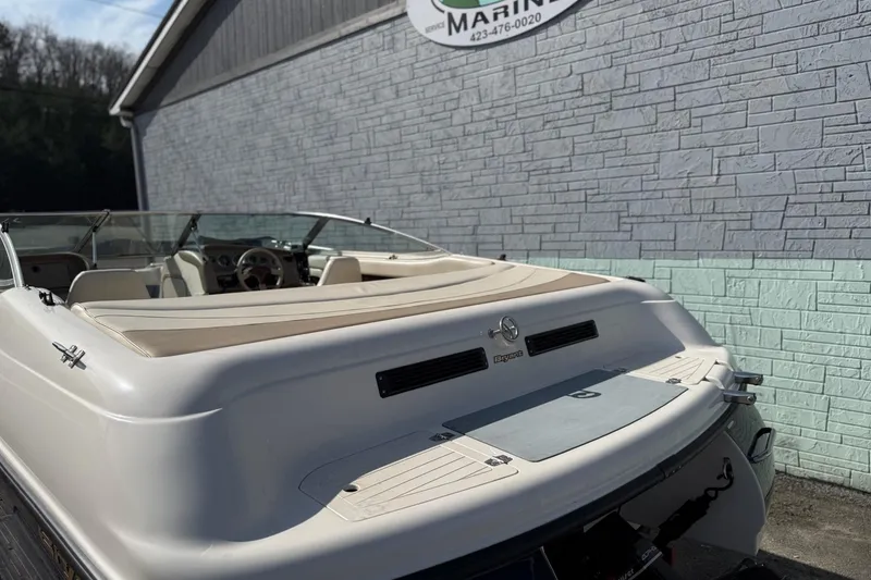 Slide: The Image of 1998 Bryant 214 Limited boat, rear view, parked near a brick wall. - 4